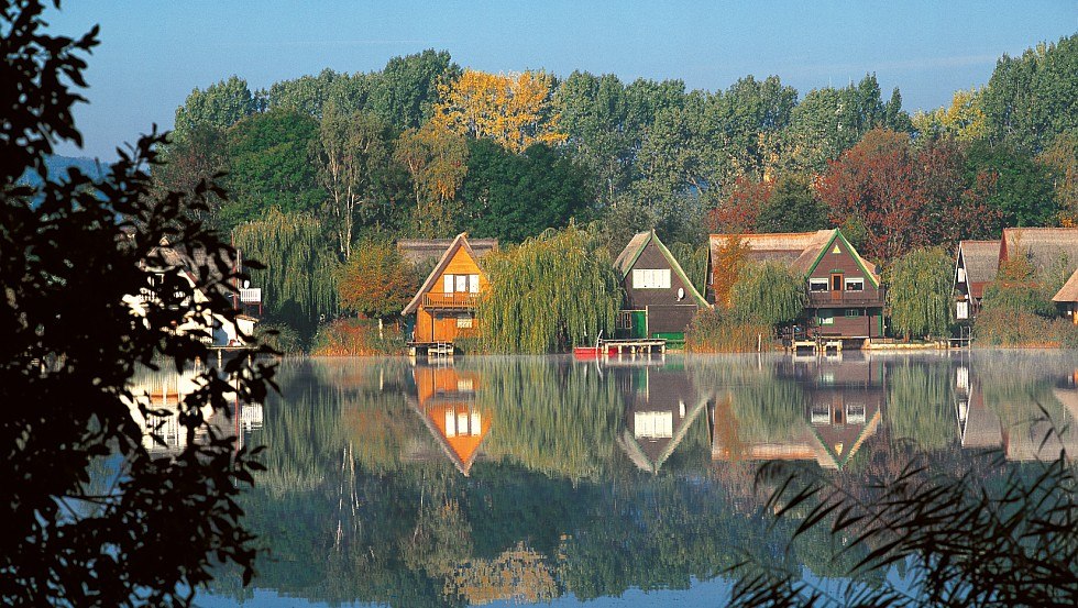 In idyllischer Lage: Reetgedeckte Häuser am Teterower See, © TMV/Grundner