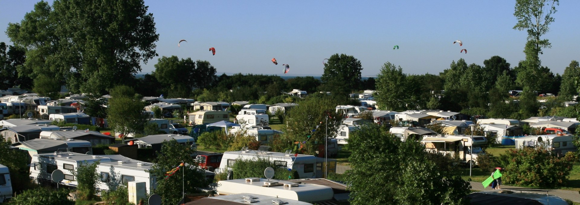 Blick über den Platz im Hintergrund die Kitesurfer auf dem Wasser, © Ferien- und Freizeitpark/Jastrow