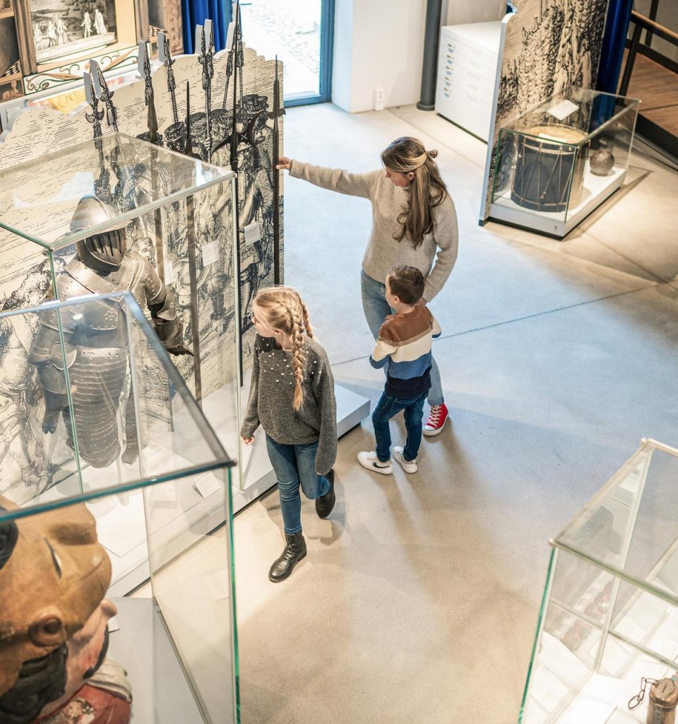 Eine Familie schaut sich interessiert Ausstellungsstücke im stadtgeschichtlichen Museum Wismar SCHABBELL an. , © TMV/Tiemann