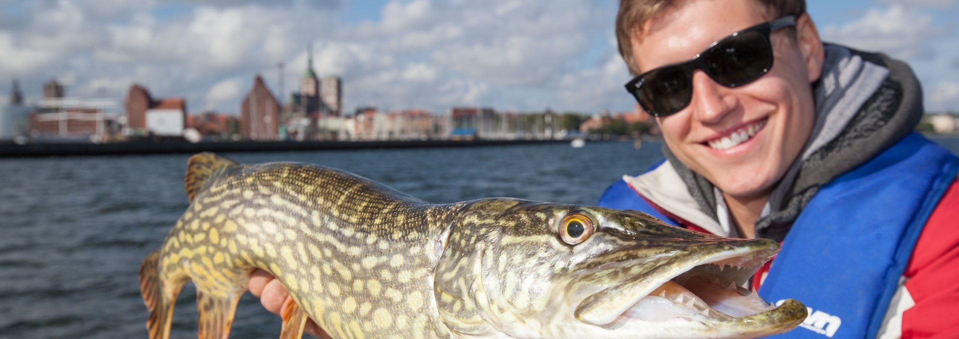 Angler mit seinem Fischfang, © TMV/Läufer