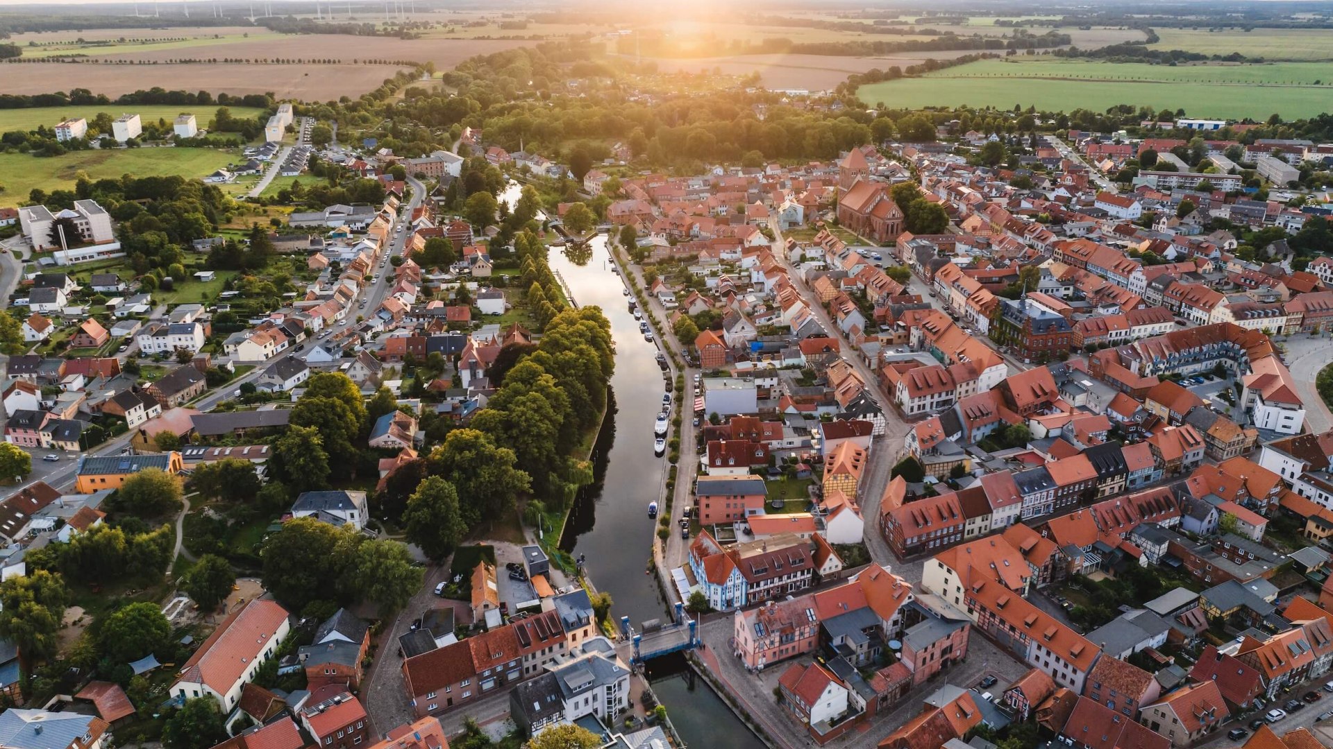 Blick aus der Luft auf die Stadt Plau am See zum Sonnenuntergang. Im Zentrum ist die Hubbrücke zu sehen.