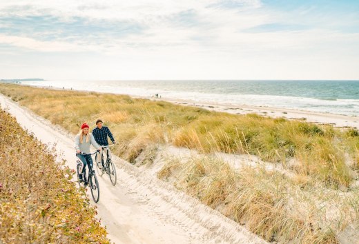 Eine gemütliche Radtour entlang der malerischen Dünen auf der Insel Hiddensee, mit Blick auf die Ostsee im Hintergrund.