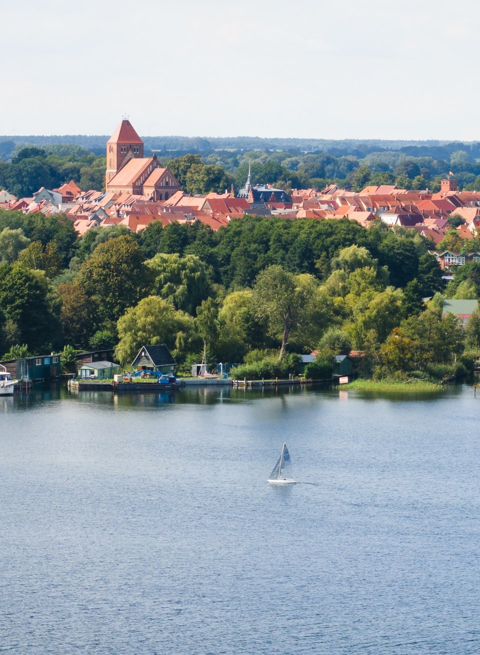 Das charakteristische Farbschema – blaues Wasser, grüne Wälder, roter Backstein – kommt beim Segeln auf dem See besonders gut zur Geltung., © TMV/Gross