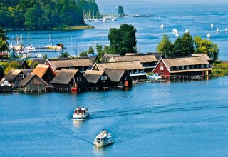 Eingebettet in einer wunderschönen Wald-und Seenlandschaft erscheint die Röbeler Bucht mit ihren kleinen Fischerhäuschen und Segelbooten, © TMV/Kuhnle Tours