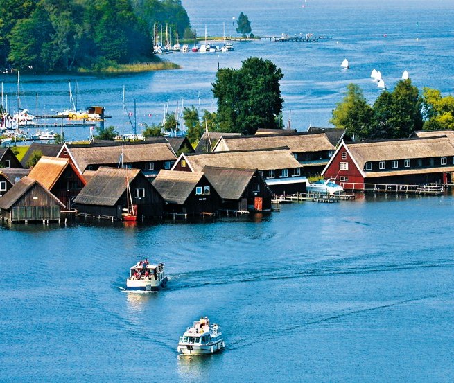 Eingebettet in einer wunderschönen Wald-und Seenlandschaft erscheint die Röbeler Bucht mit ihren kleinen Fischerhäuschen und Segelbooten, © TMV/Kuhnle Tours