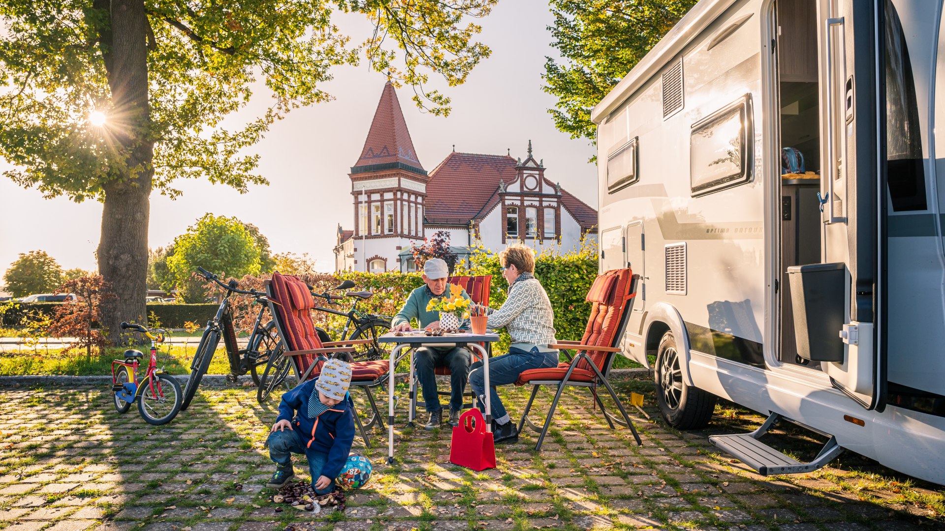 Oma, Opa und Enkel vor dem Reisemobil auf dem Stellplatz am Stadthafen in Neustrelitz, © TMV/Tiemann