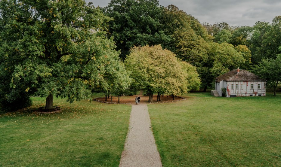 Ein idyllischer Spaziergang durch den Park des Romantik Hotels Gutshaus Ludorf: Umgeben von alten Bäumen und grünen Wiesen, lädt die Natur zur Erholung und Entspannung ein.