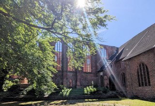 Johannisklsiter im Sonnenschein und Rosengarten im Vordergrund.
Anfang Mai, © HANSESTADT Stralsund