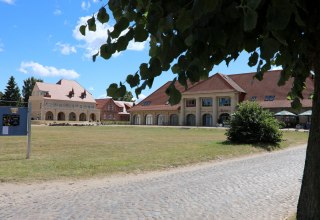 Die Remise des "Schloss Stolpe" mit Restaurant.  Im Hintergrund Teile des vom Schloss abgetrennten Westflügels., © Dr. Lüling, GF SaH