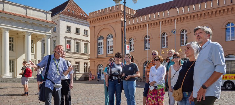 Stadtführer mit einer Gästegruppe auf dem Schweriner Markt vorm Rathaus., © Oliver Borchert