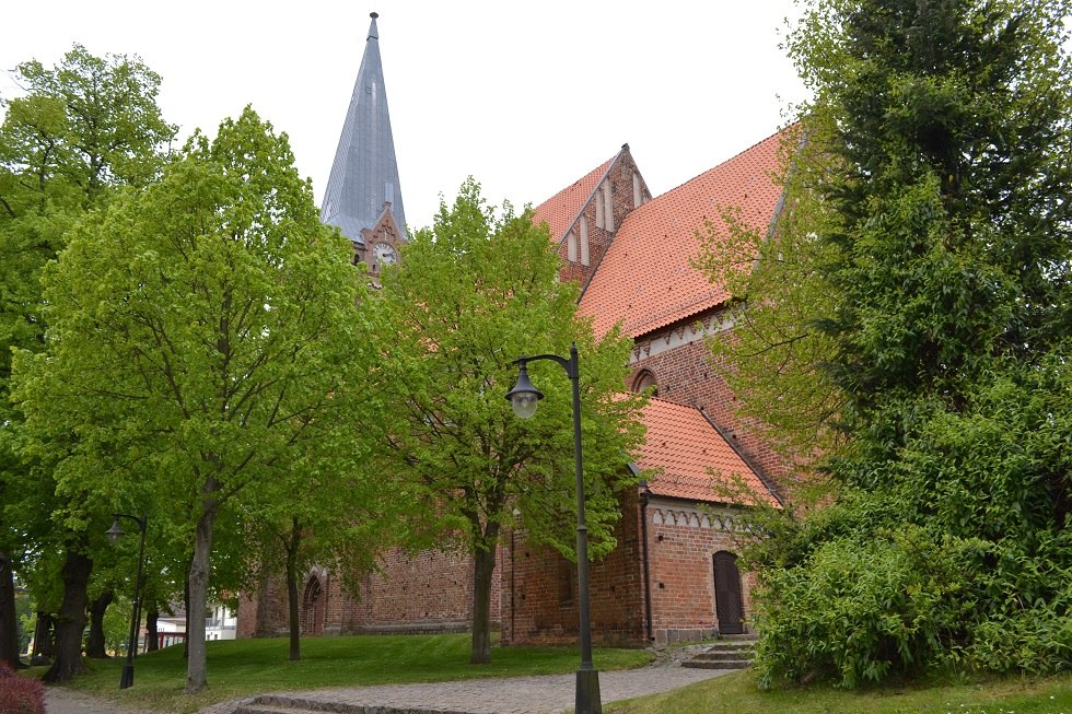 Südseite der Kirche mit Rundweg im Grün der Bäume., © Lutz Werner