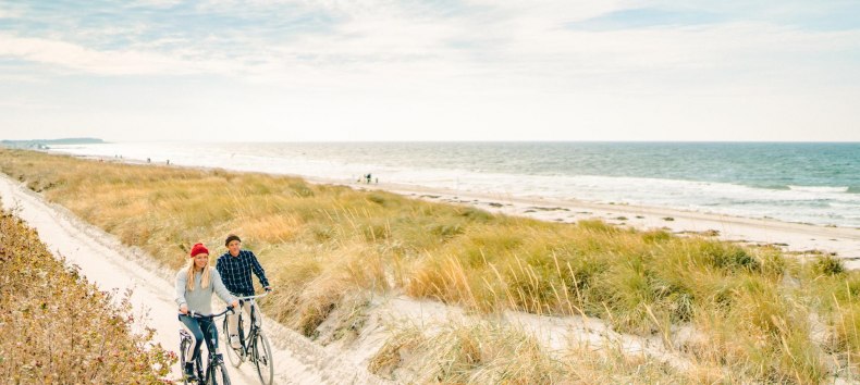 Eine gemütliche Radtour entlang der malerischen Dünen auf der Insel Hiddensee, mit Blick auf die Ostsee im Hintergrund.