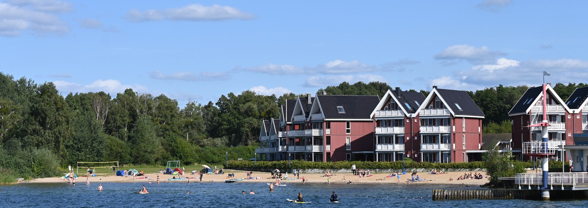 Startpunkt für Schwimmer, Surfer und SUPler: Der Badestrand im Hafendorf Müritz verfügt über eine kleine Seebrücke, eigene Sanitäranlagen und eine Freiluftdusche., © KUHNLE-TOURS