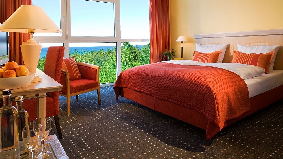 Alle Zimmer bieten mit großen Fenstern einen Ausblick auf die knorrigen Kiefern oder die Dünenlandschaft mit der Ostsee, © Strandhotel Fischland