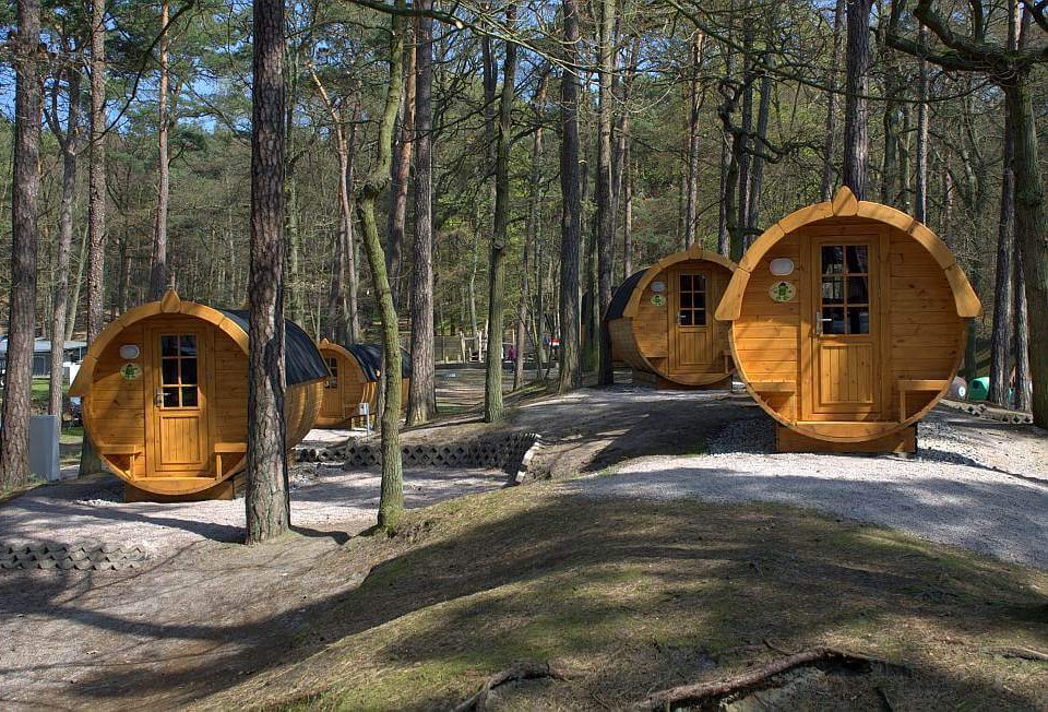 Die Schlaffässer auf dem Campingplatz Pommernland unter Bäumen auf der Insel Usedom, © A. Beggerow