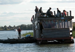 Unterwegs mit dem Floß - konzentriert am Steuer oder entspannt auf dem Oberdeck, © TOKON