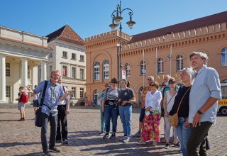 Stadtführer mit einer Gästegruppe auf dem Schweriner Markt vorm Rathaus., © Oliver Borchert