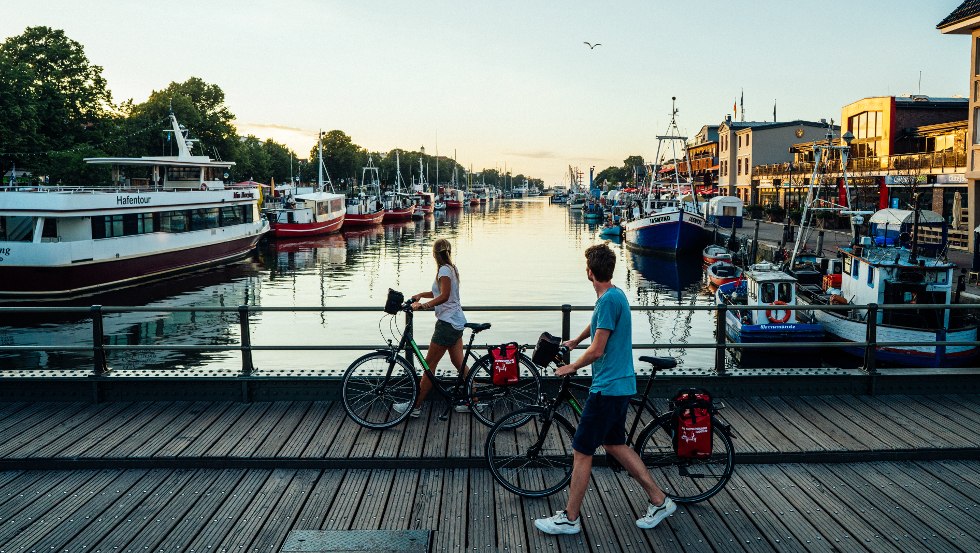 Ein Spaziergang über die Bahnhofsbrücke mit Blick auf den Alten Strom in Warnemünde bei Sonnenuntergang, © TMV/Gänsicke