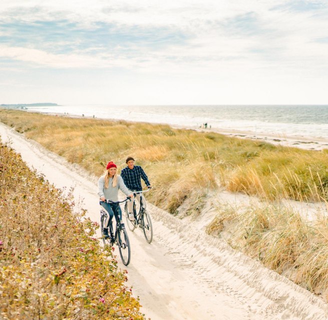 Eine gemütliche Radtour entlang der malerischen Dünen auf der Insel Hiddensee, mit Blick auf die Ostsee im Hintergrund.