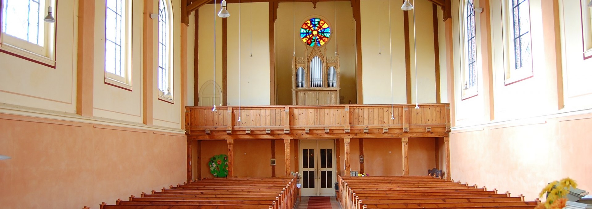 Innenansicht der Dorfkirche mit Orgel und hölzernem Gebälk, © Foto: Karl-Georg Haustein