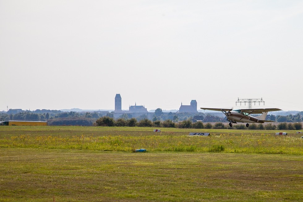 Flugzeug beim Start. Im Hintergrund die Silhouette von Wismar., © Frank Burger