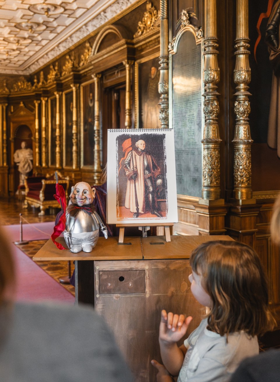 Begeisterte Kinder erleben eine magische Führung durch das Schweriner Schloss, begleitet von einem faszinierenden Puppenspiel