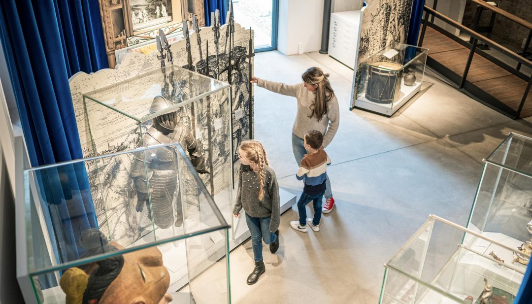 Eine Familie schaut sich interessiert Ausstellungsstücke im stadtgeschichtlichen Museum Wismar SCHABBELL an. , © TMV/Tiemann