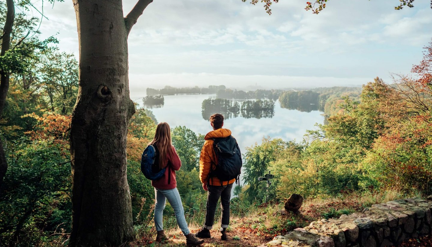 Ein Pärchen schaut vom Reiherberg in Feldberg von oben auf den Feldberger Haussee