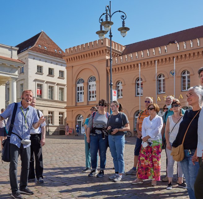 Stadtführer mit einer Gästegruppe auf dem Schweriner Markt vorm Rathaus., © Oliver Borchert