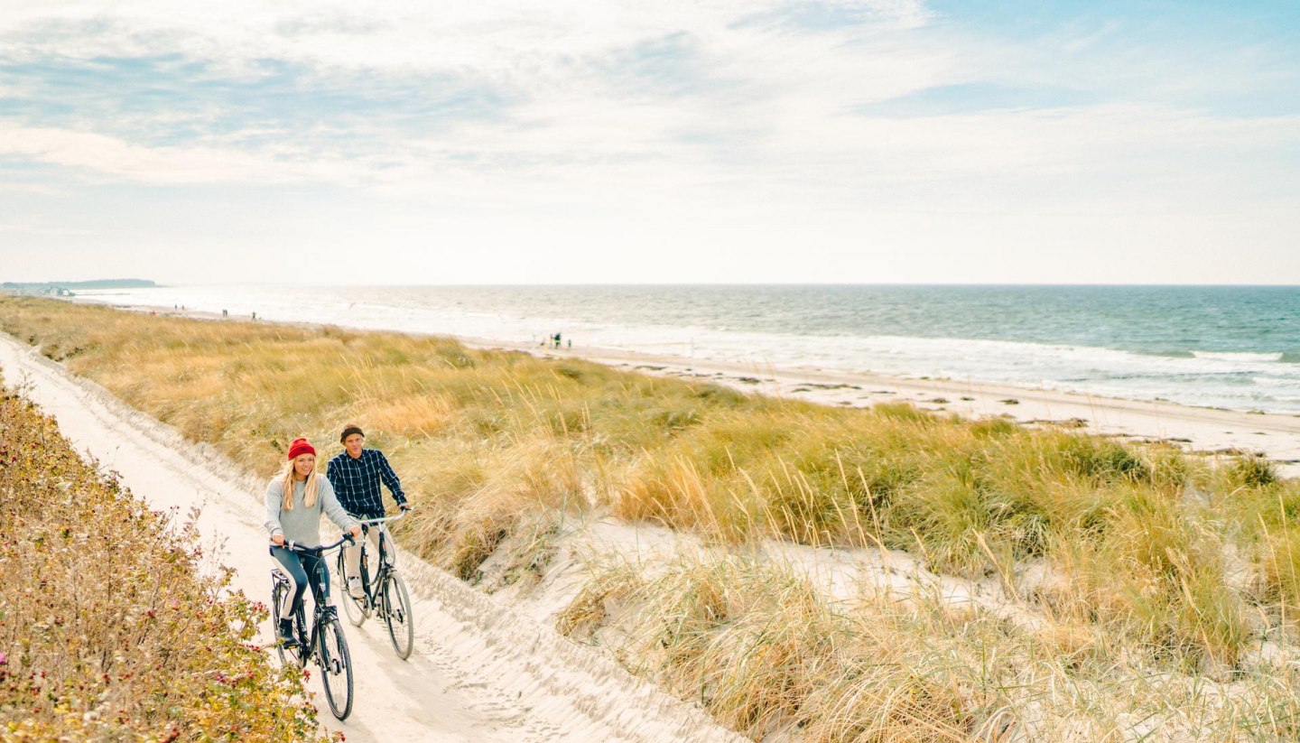 Eine gemütliche Radtour entlang der malerischen Dünen auf der Insel Hiddensee, mit Blick auf die Ostsee im Hintergrund.