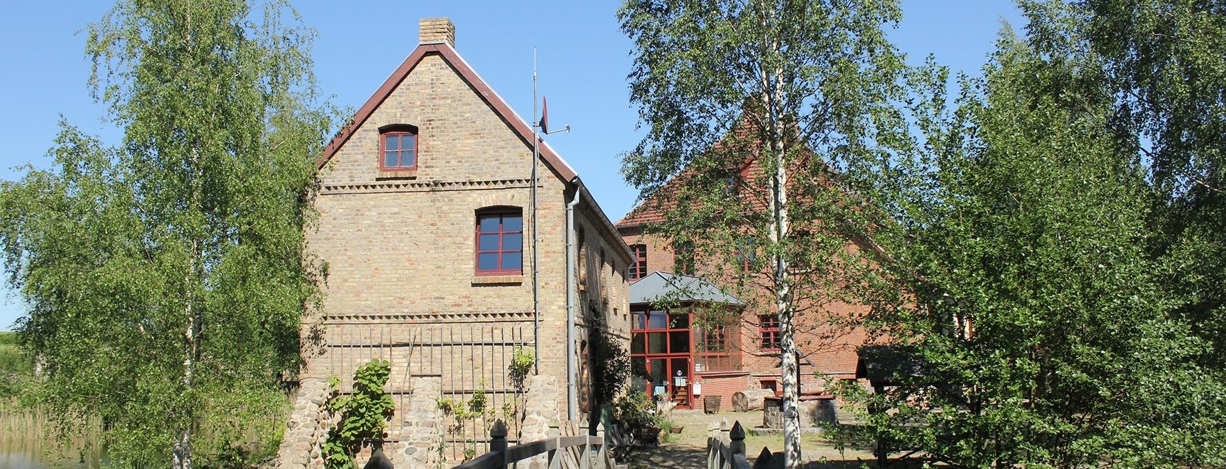 Die Wasserburg Liepen und das Gesindehaus kann man vom Park aus über eine kleine Holzbrücke erreichen., © Burmeister