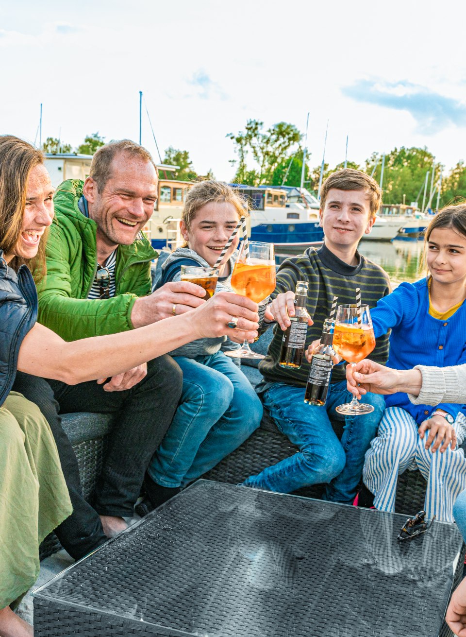 Schöner Ausklang in der Pirate’s Bar: Mit den Füßen im Sand stoßen die beiden befreundeten Familien auf den tollen Urlaub an., © TMV/Tiemann