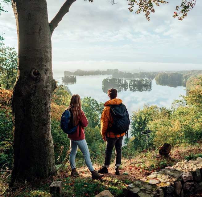 Ein Pärchen schaut vom Reiherberg in Feldberg von oben auf den Feldberger Haussee