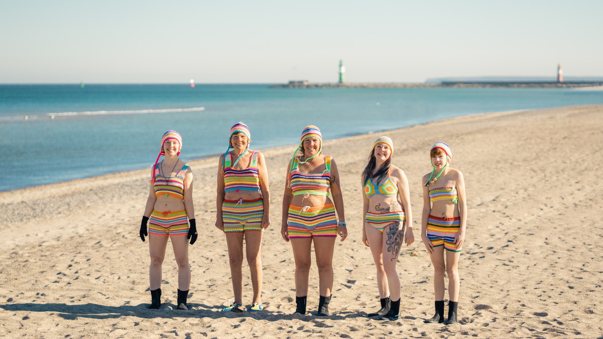 Eine Familie geht Eisbaden mit gehäkelter Badebekleidung am Strand von Warnemünde, © TMV/Gross