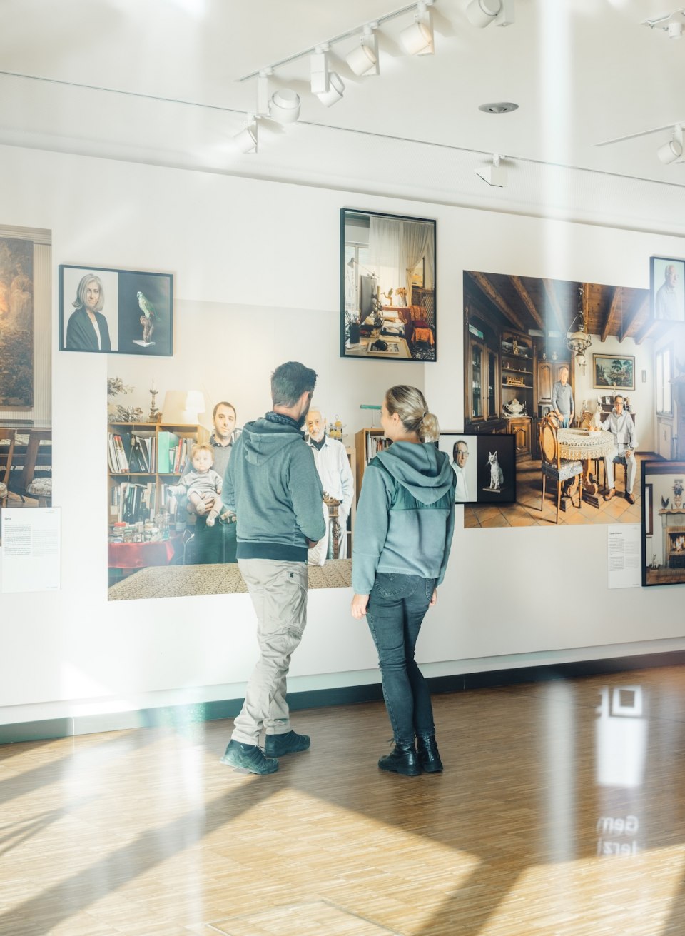 Zwei Besucher betrachten Fotografien an einer Wand in der Ausstellung des Max Hünten Hauses in Zingst.