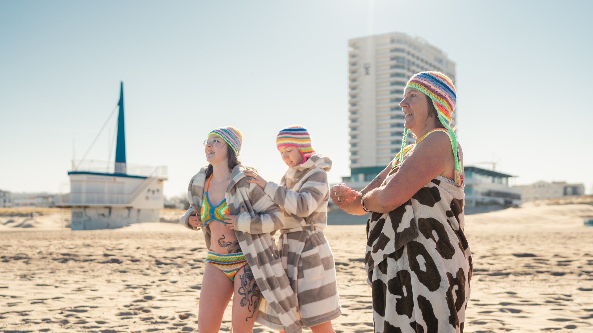 Die Familie zieht sich zum Eisbaden im Winter am Rettungsturm von Warnemünde um., © TMV/Gross