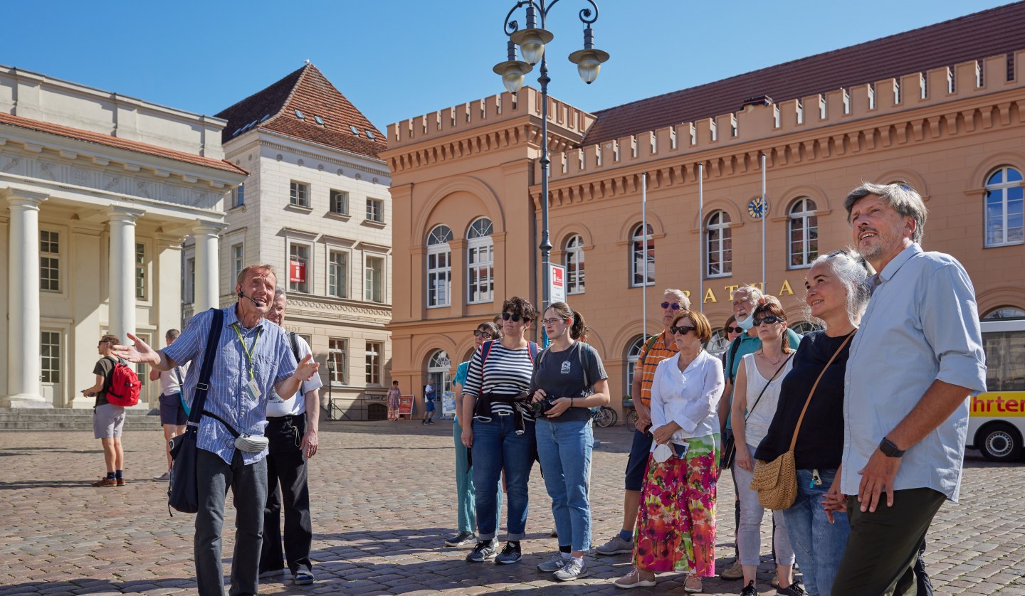 Stadtführung, Am Markt - im Hintergrund das Säulengebäude und das historische Rathaus., © Stadtmarketing Schwerin, Oliver Borchert